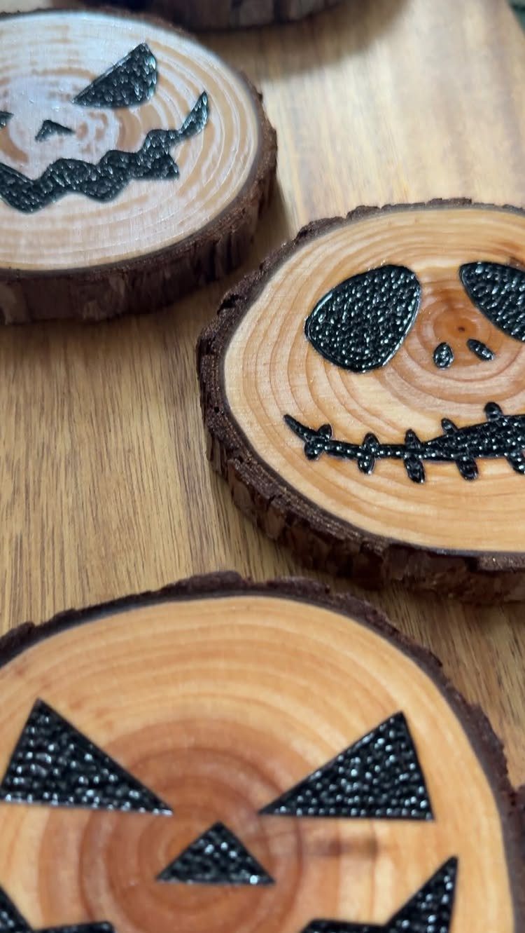 Pyrography Patterns Free to Try: 6 Wood Burning Ideas 4 Wood-burned jack-o'-lantern faces on circular wood slices with natural bark edges.
