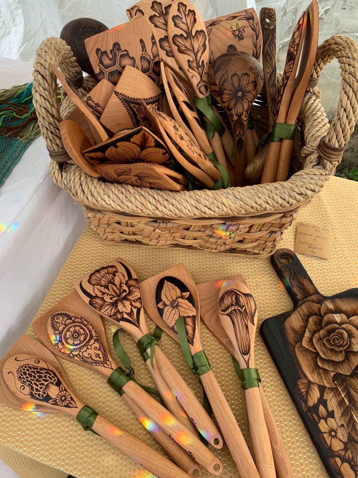 Pyrography Patterns Free to Try: 6 Wood Burning Ideas 1 Wood-burned kitchen spoons with floral designs arranged in a basket and on a table.