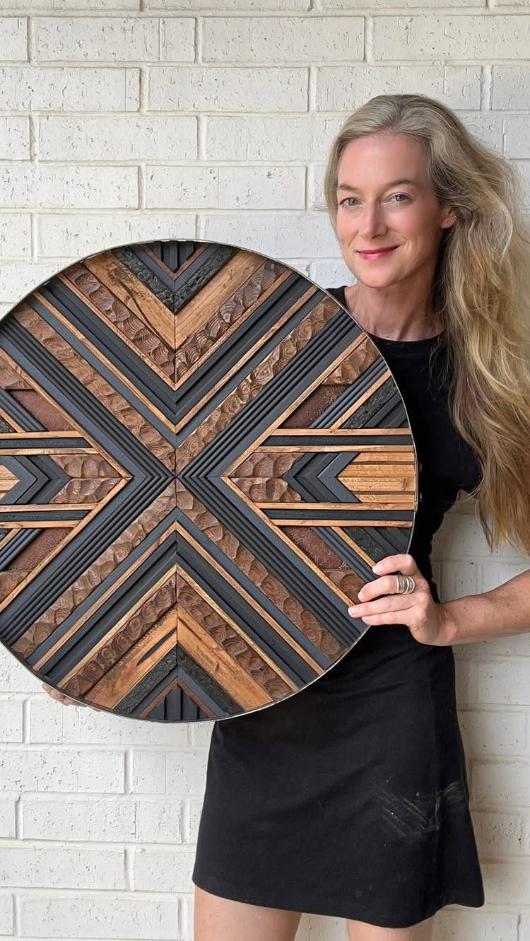 14 Reclaimed Wood Projects for Rustic Home Decor 8 Circular reclaimed wood wall art with geometric patterns held by a woman.