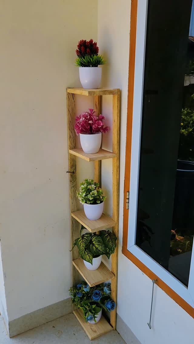14 Reclaimed Wood Projects for Rustic Home Decor 14 Wooden plant stand with five shelves holding white pots of colorful flowers.