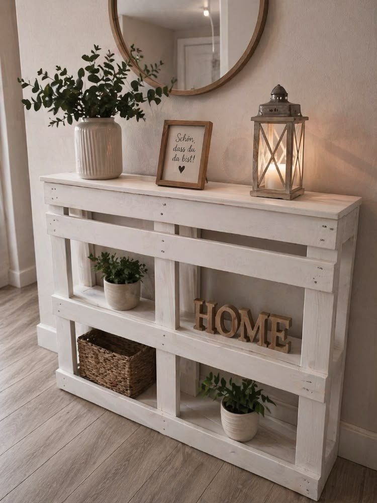White pallet wood console table decorated with plants, a lantern, and home decor.