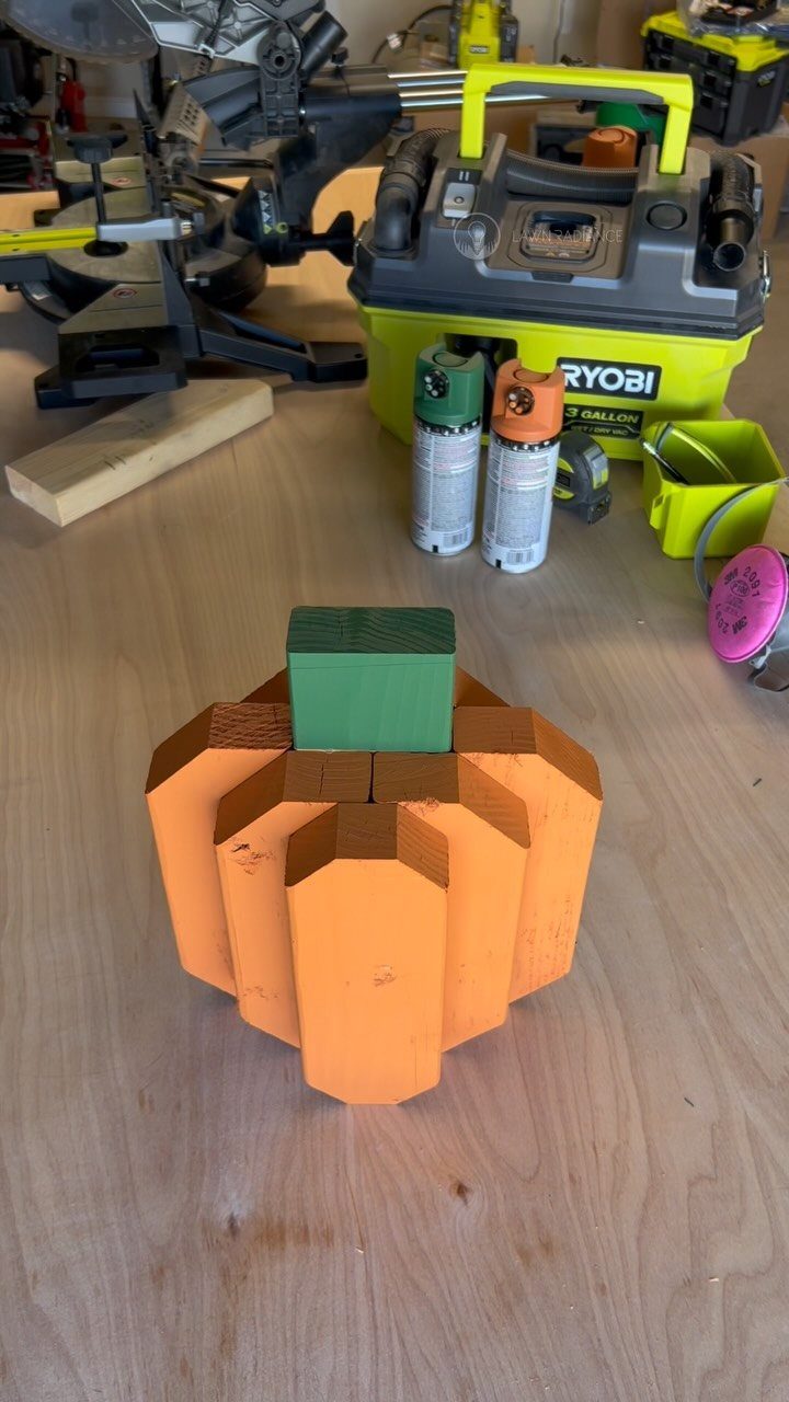 13 Scrap Wood Art Ideas for Using Up Your Leftover Boards 10 Wooden pumpkin made of orange blocks with a green stem on a workbench.