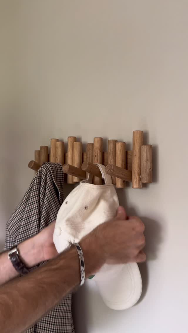 13 Scrap Wood Art Ideas for Using Up Your Leftover Boards 5 Wooden hook rack made of scrap wood cylinders holding a hat and trousers.