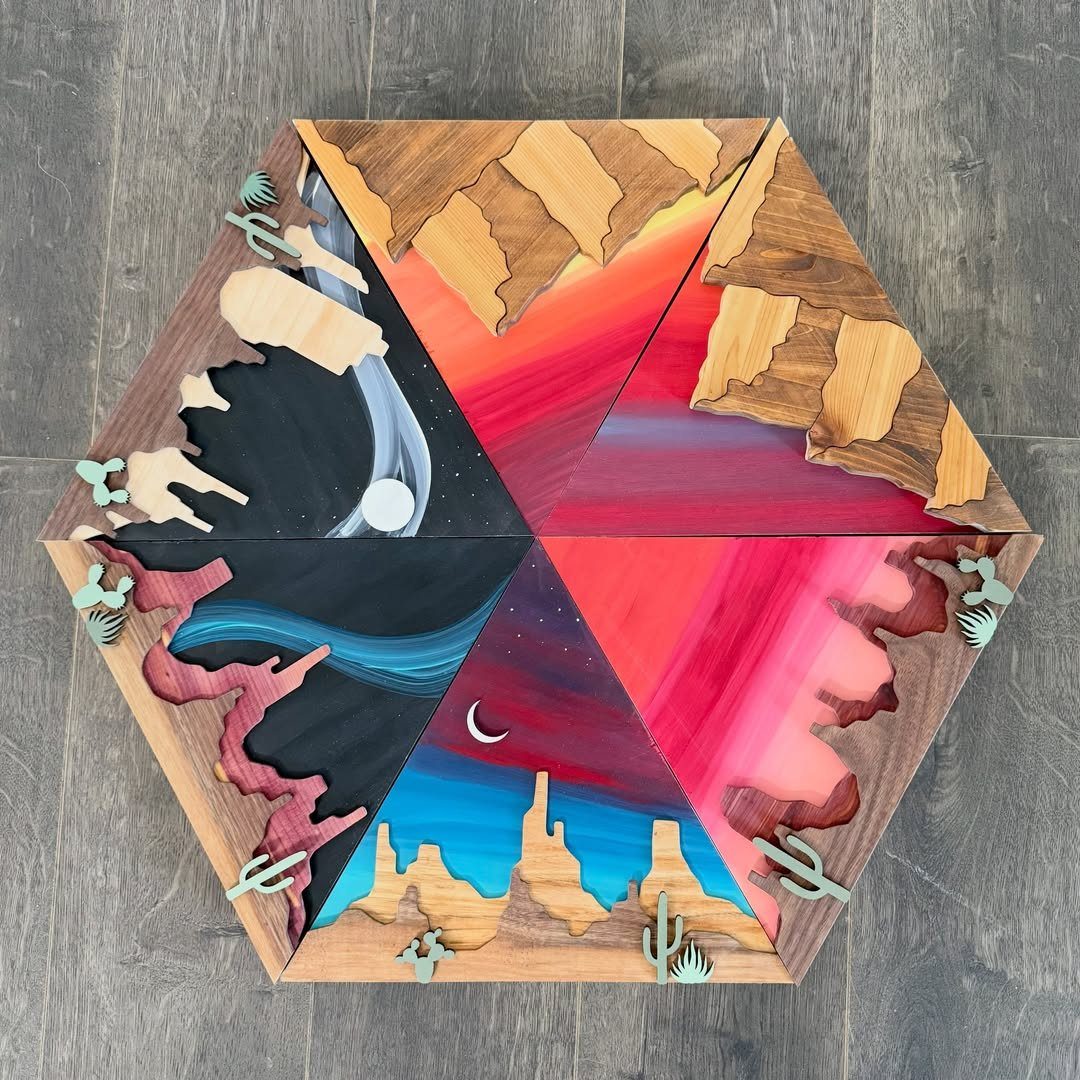 13 Scrap Wood Art Ideas for Using Up Your Leftover Boards 1 Hexagonal layered wood art depicting a colorful desert landscape with mountains and cacti.