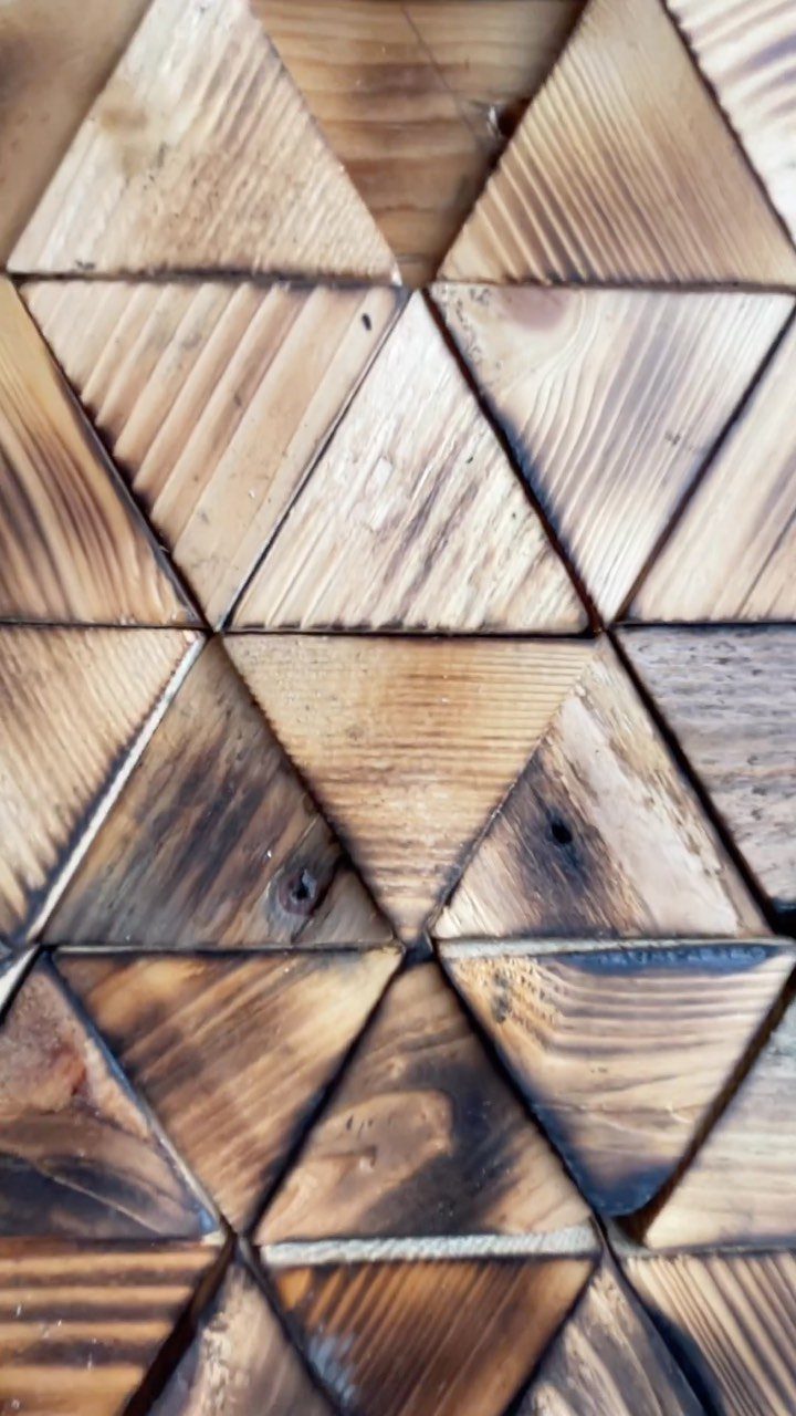 13 Scrap Wood Art Ideas for Using Up Your Leftover Boards 8 Triangular slices of wood in various brown tones arranged in a geometric mosaic pattern.