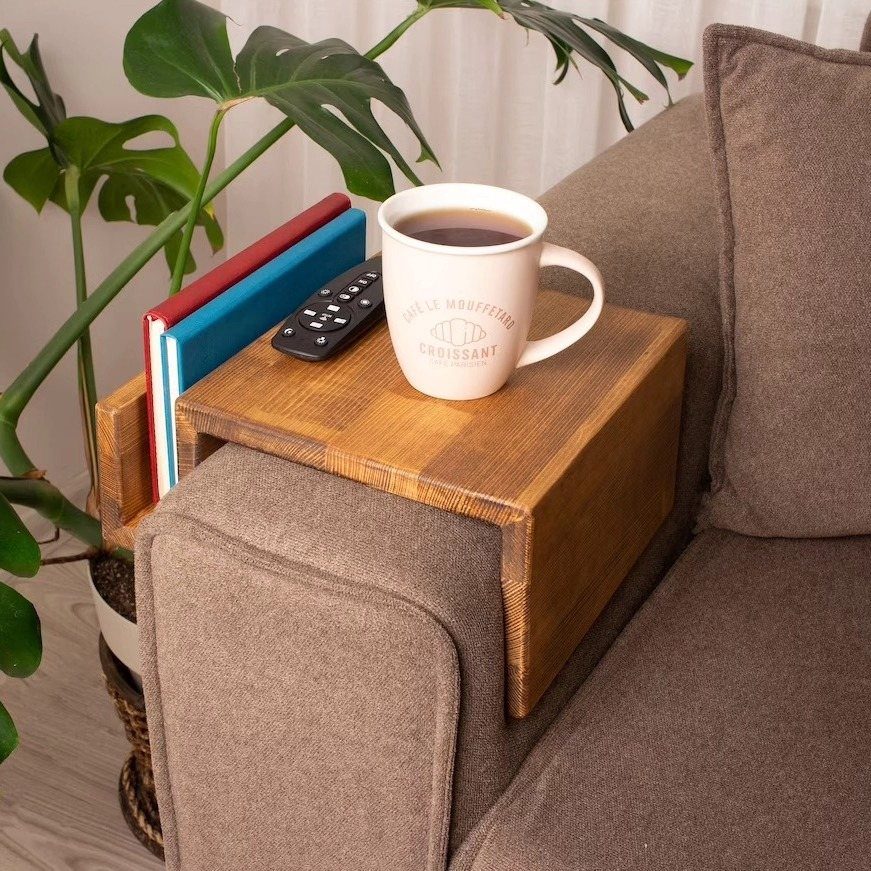 13 Small Wood Craft Ideas for Beginners and Scrap Wood 10 Wooden couch caddy on a brown sofa arm holding coffee, remote, and books.