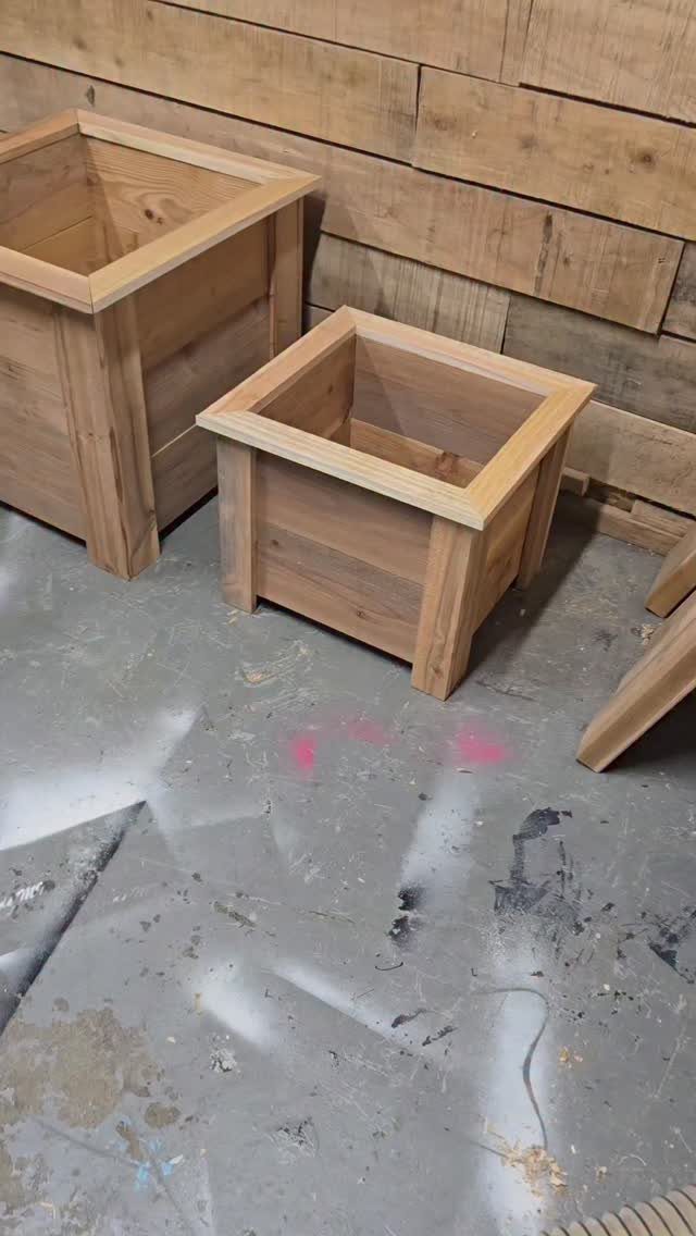 13 Small Wood Craft Ideas for Beginners and Scrap Wood 5 Two square wooden planter boxes of different sizes against a wooden plank wall.