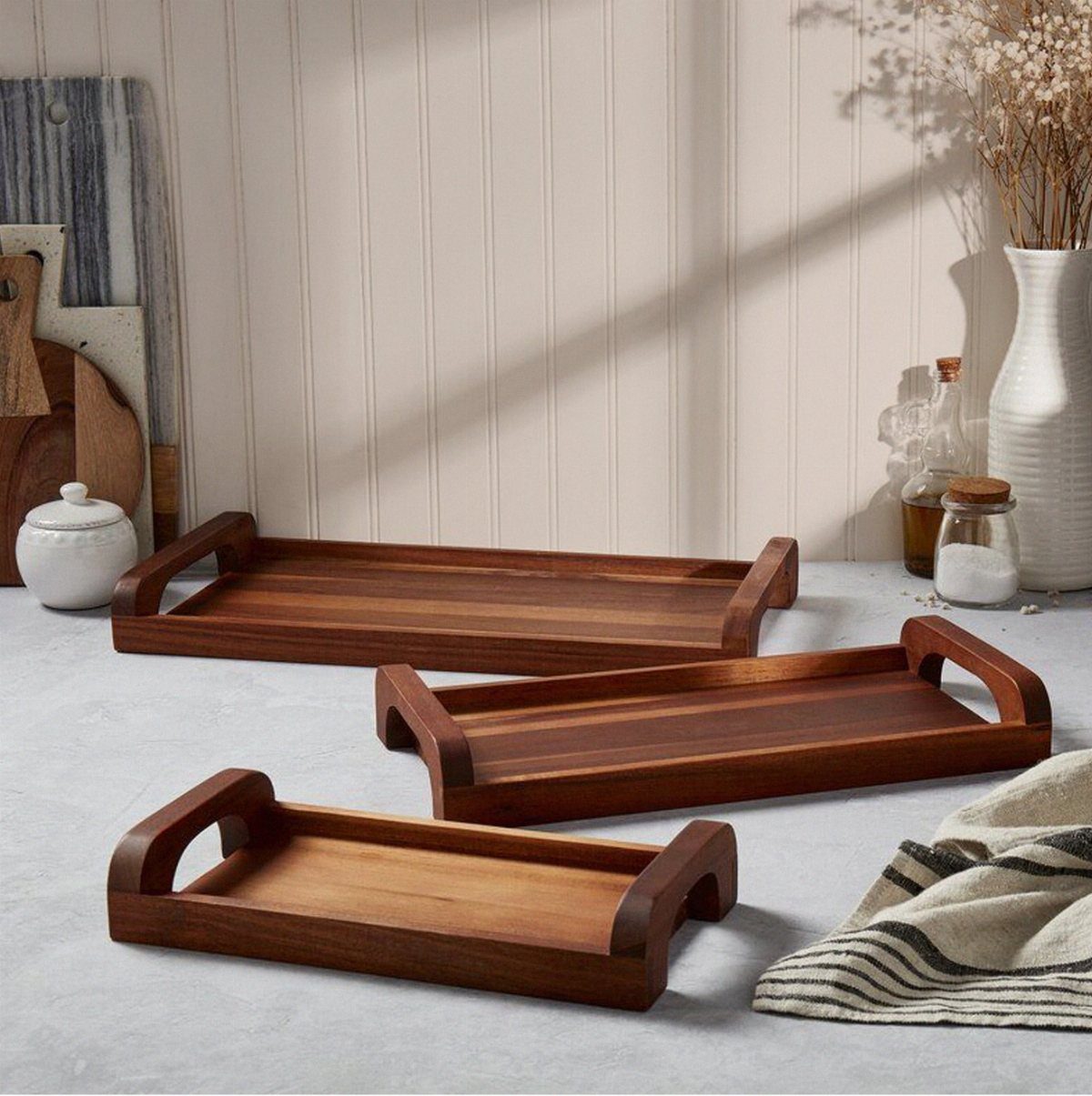 13 Small Wood Craft Ideas for Beginners and Scrap Wood 4 Three brown wooden serving trays of different sizes on a light grey surface.