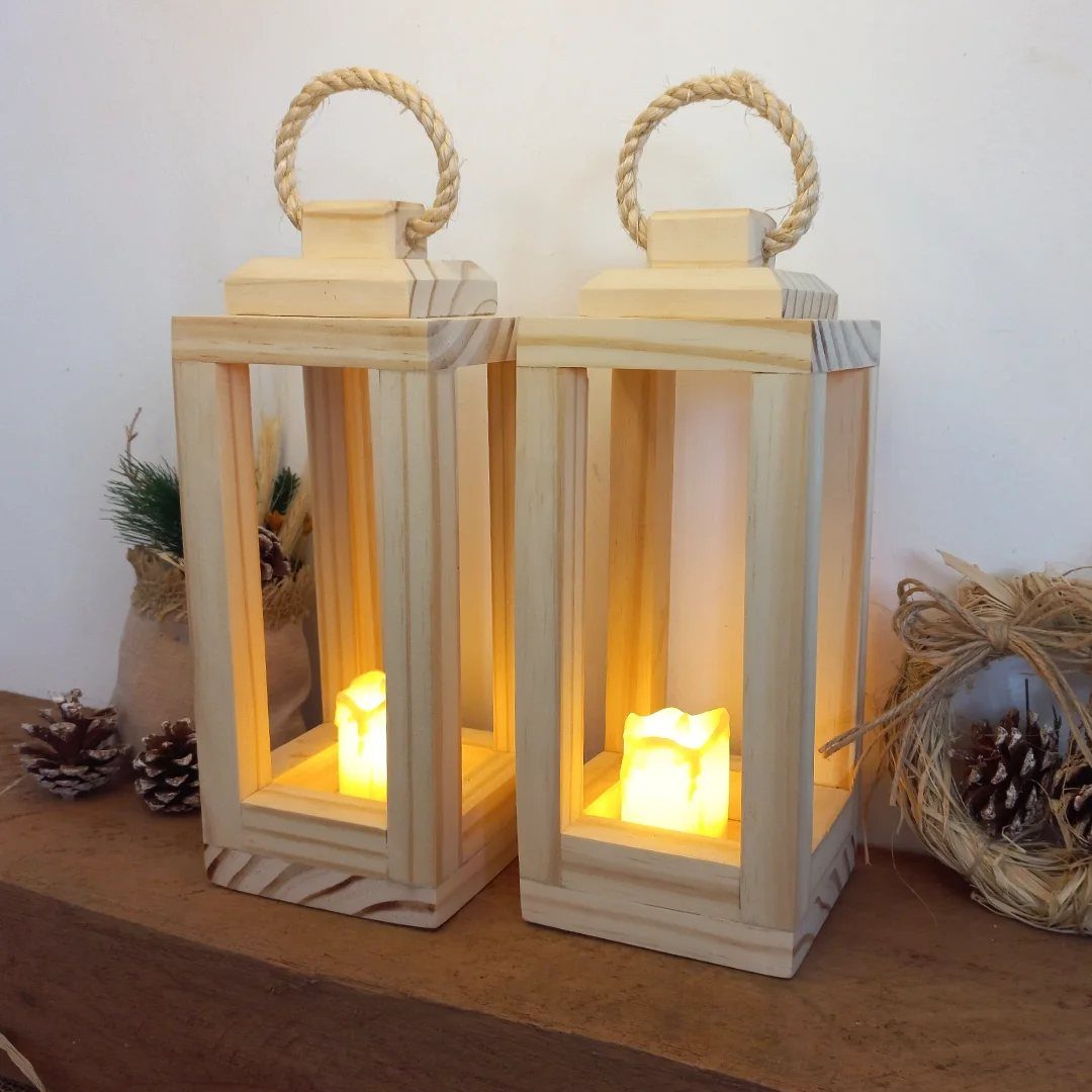 21 Small Wood Projects for Christmas You Can Make 11 Two light wood lanterns with rope handles and glowing candles on a wooden surface.