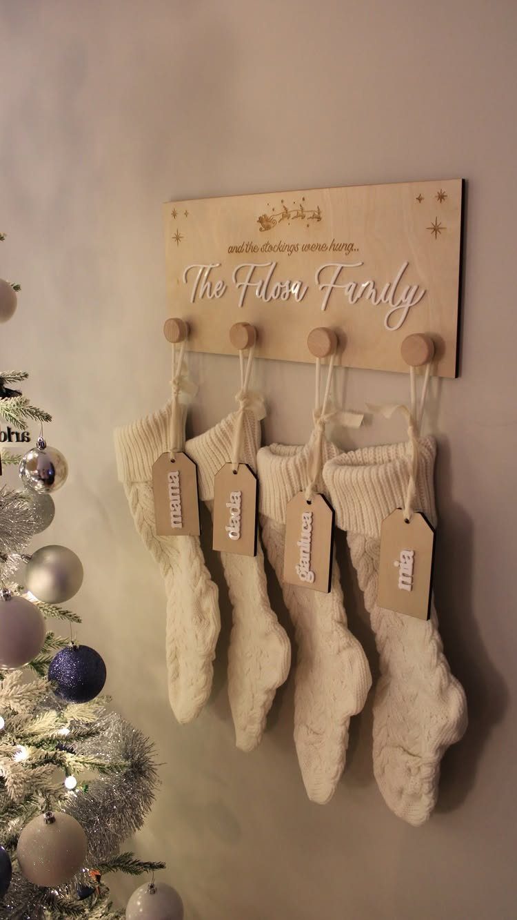 21 Small Wood Projects for Christmas You Can Make 18 Wooden wall-mounted stocking holder with four white knit stockings and personalized name tags.