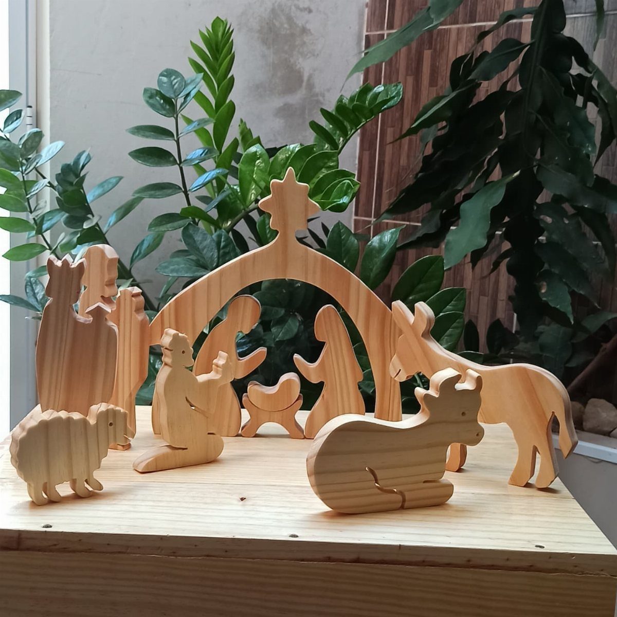 21 Small Wood Projects for Christmas You Can Make 17 Wooden nativity scene figures with a stable arch on a light wood table.