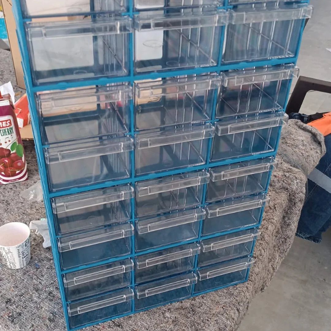 12 Small Workshop Storage Ideas for Tight Spaces 3 Blue plastic organizer with multiple clear storage drawers on a grey surface.