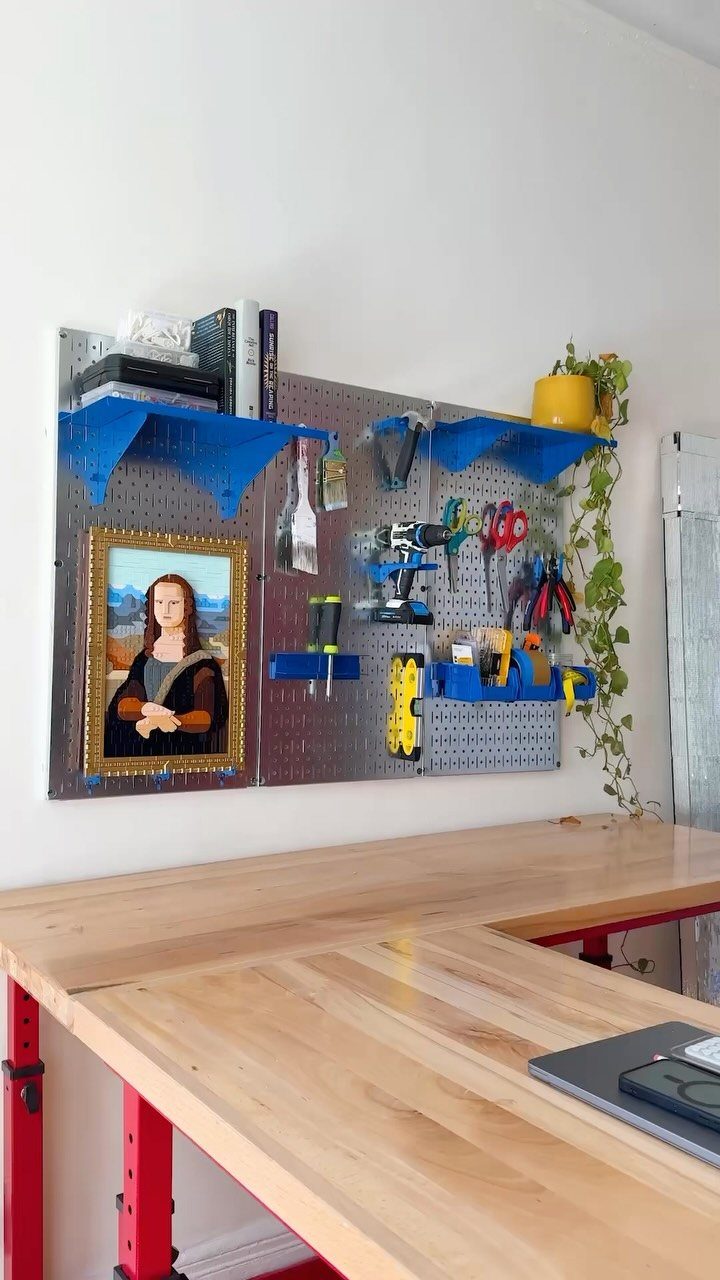 12 Small Workshop Storage Ideas for Tight Spaces 9 Grey pegboard with tools and blue shelves mounted above a wooden workbench.