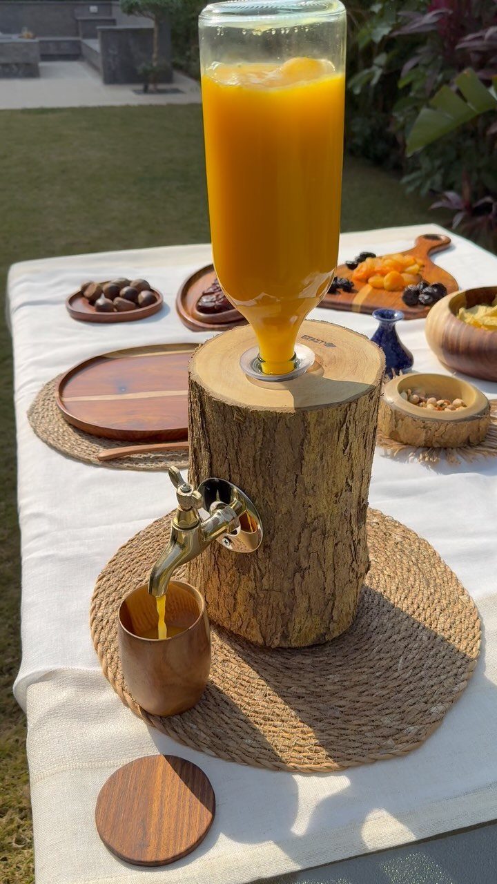 24 Summer Wood Projects for Beginners and Weekend Builders 21 Wooden log beverage dispenser with orange juice on a white outdoor table.