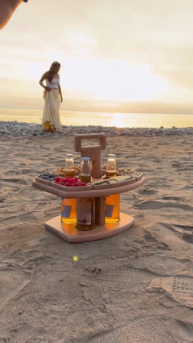 24 Summer Wood Projects for Beginners and Weekend Builders 8 Wooden picnic caddy with bottles and fruit on a sandy beach at sunset.