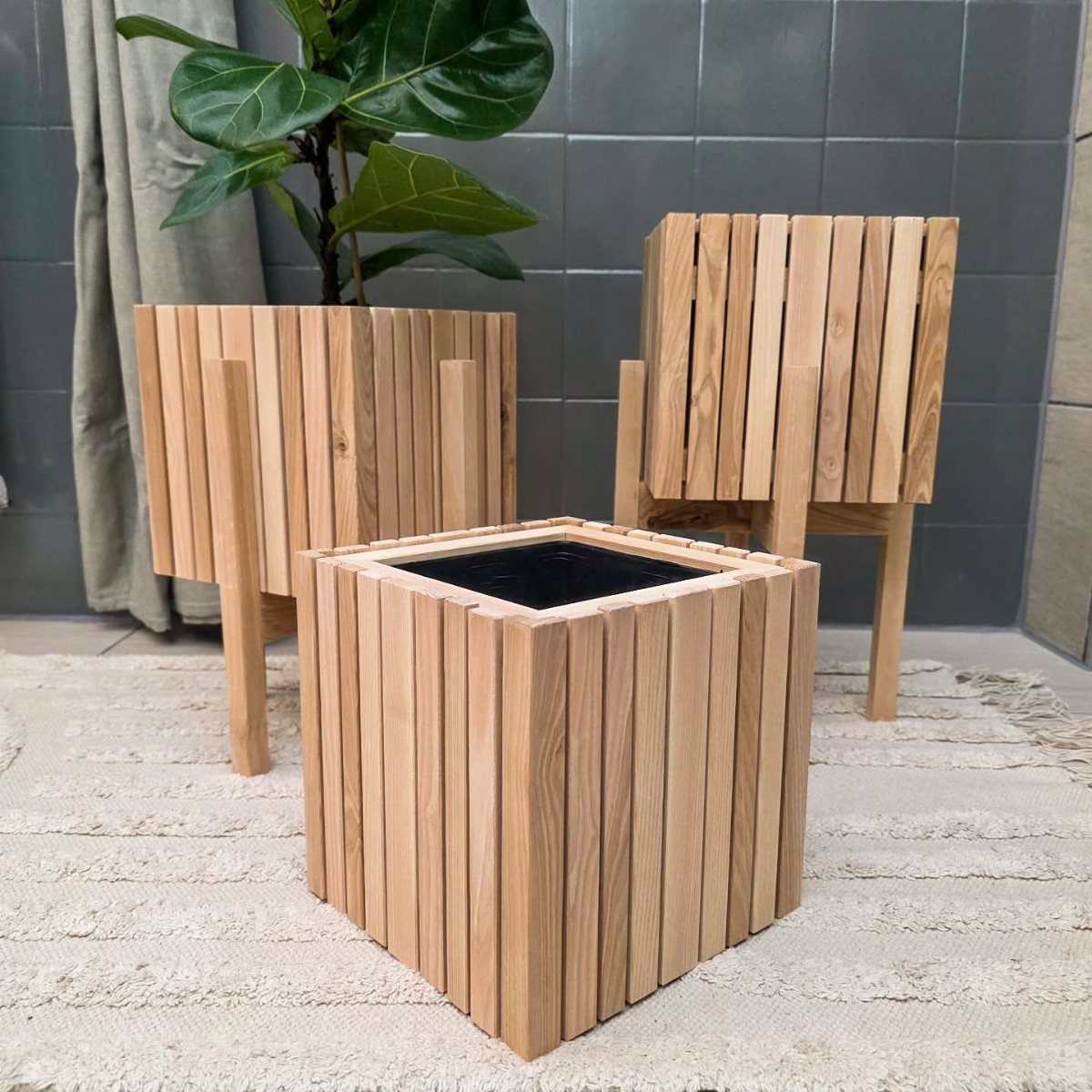 24 Summer Wood Projects for Beginners and Weekend Builders 1 Three light wood plant stands of different heights on a white textured rug.
