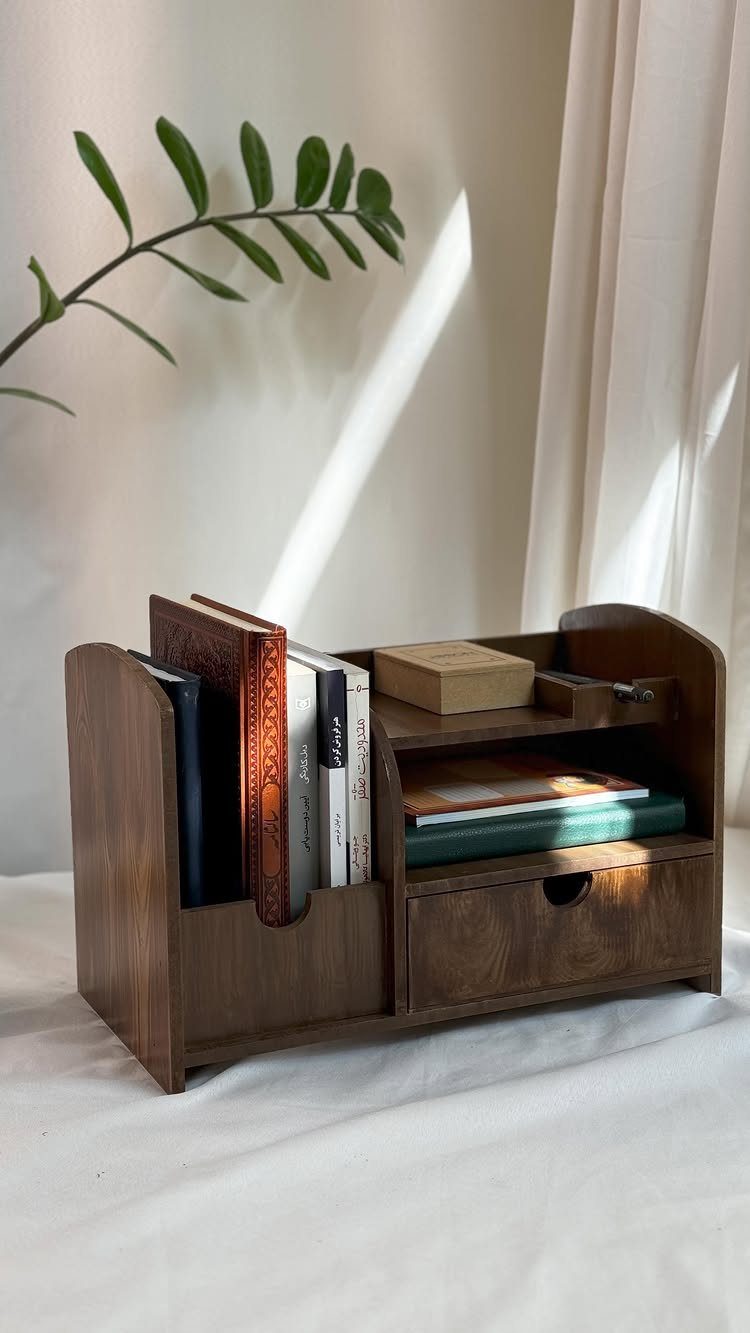 Wooden desk organizer caddy holding books and a small box on a white surface.