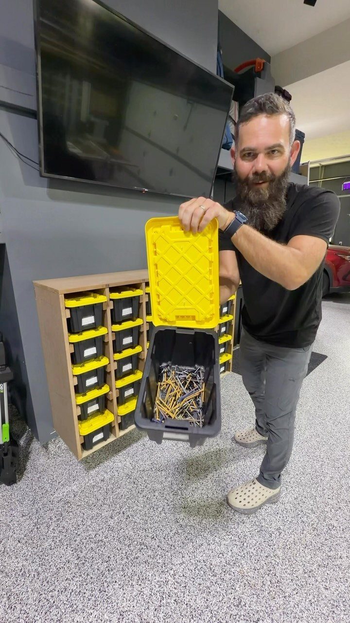 Tool Storage DIY Ideas: 7 Projects for Any Garage 4 Man holding a plastic bin of screws in front of a tool shelf.