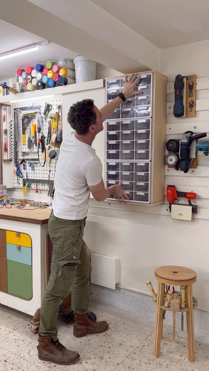 Tool Storage DIY Ideas: 7 Projects for Any Garage 7 Man organizing tools in a tall wooden cabinet with multiple clear plastic drawers.