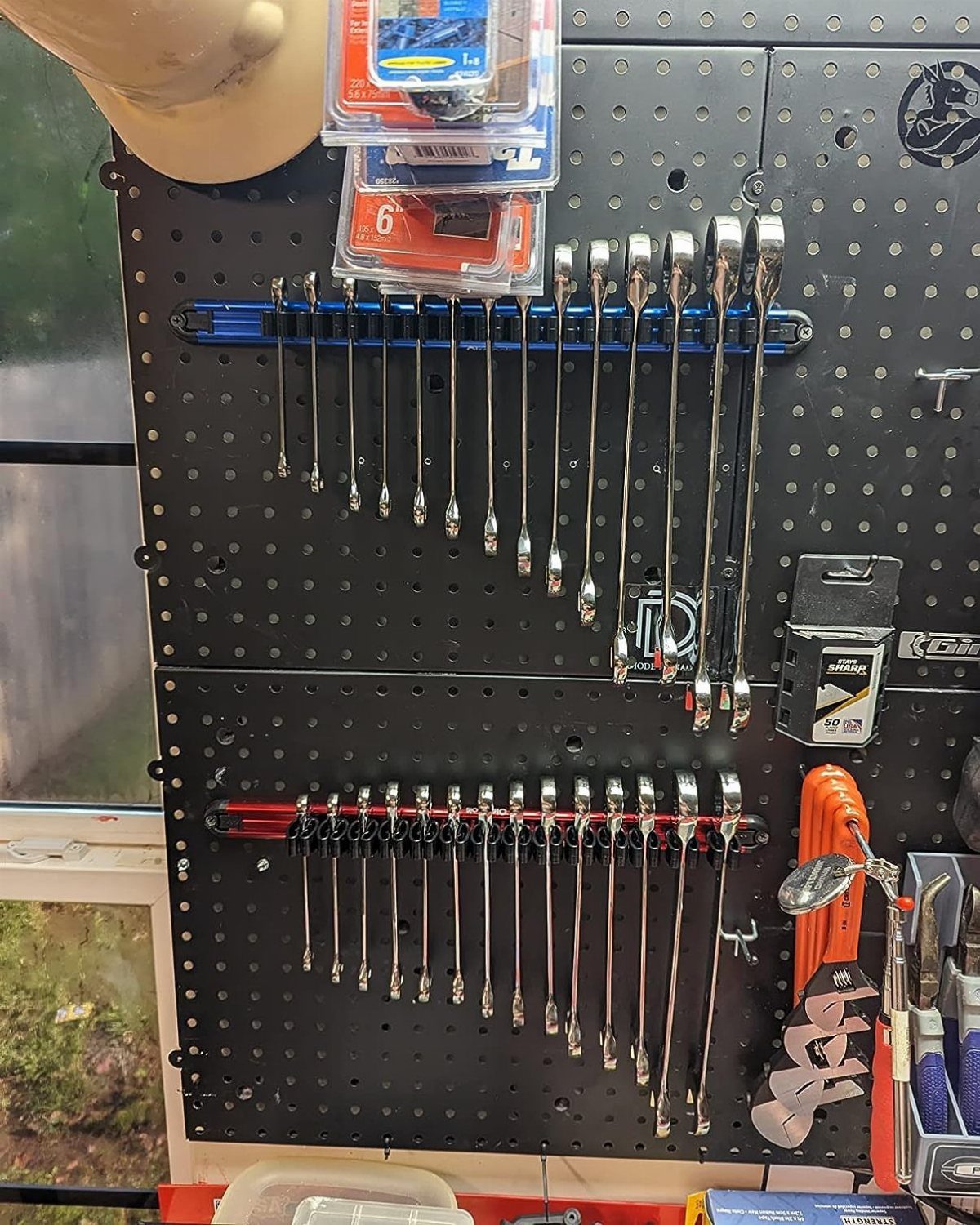 Tool Storage DIY Ideas: 7 Projects for Any Garage 1 Black pegboard wall organizing silver wrenches on racks and small plastic storage bins.