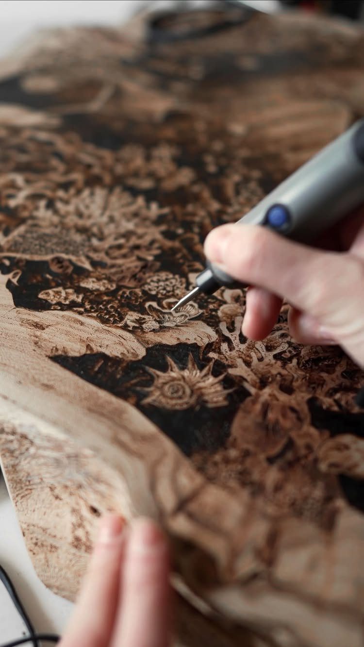 12 Wood Burn Designs for Beginners: Strokes and Patterns 7 Wood burning tool creating a detailed floral design with dark fill on wood.