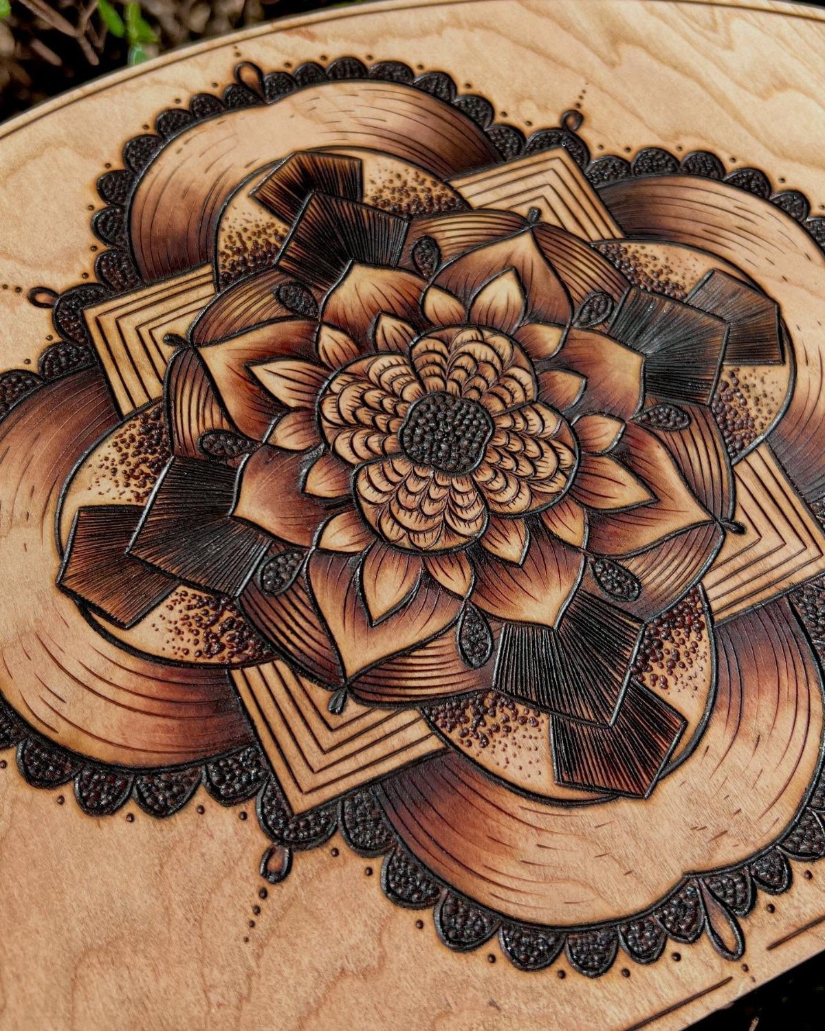 12 Wood Burn Designs for Beginners: Strokes and Patterns 2 Symmetrical wood-burned mandala design with intricate floral patterns and shading on light wood.