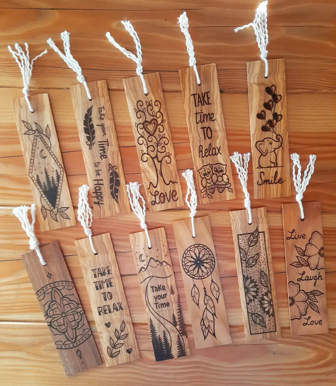 12 Wood Burn Designs for Beginners: Strokes and Patterns 12 Wooden bookmarks with various wood burned designs and white strings on a wooden table
