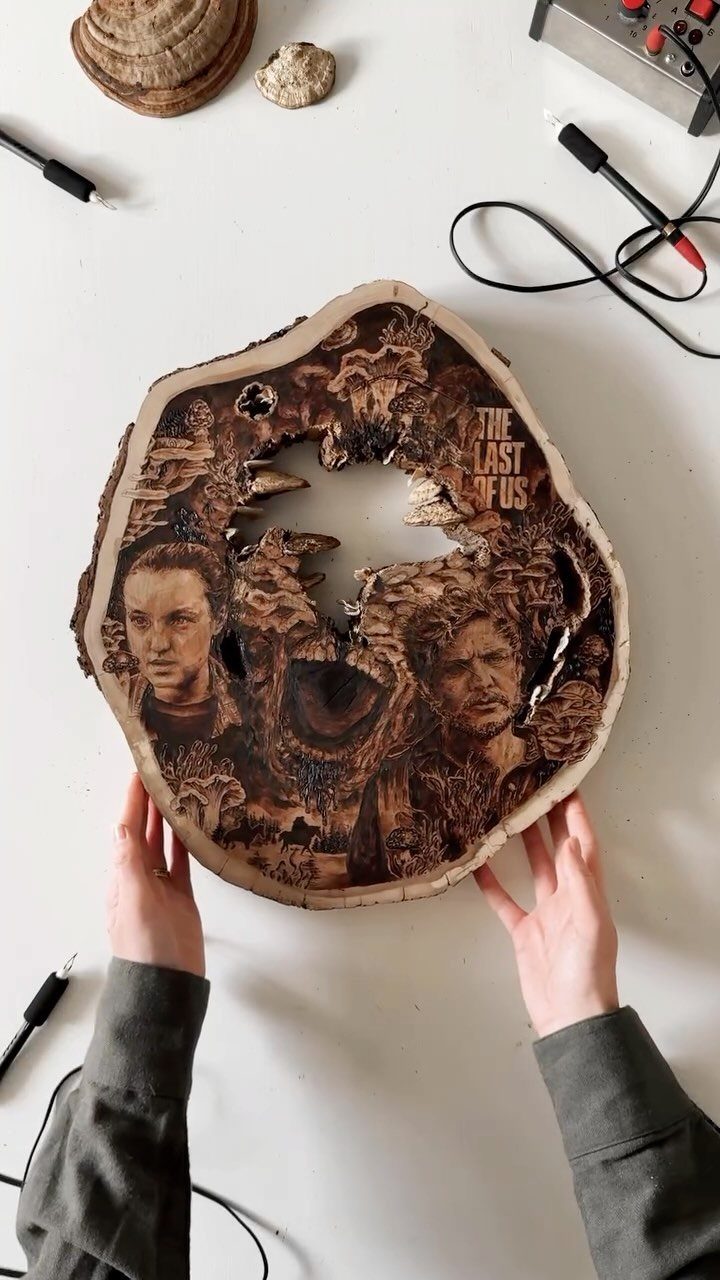 Wood Burning Art: 8 Ideas for Spoons, Coasters and More 7 Wood-burned portrait of characters on a natural wood slice held by two hands.