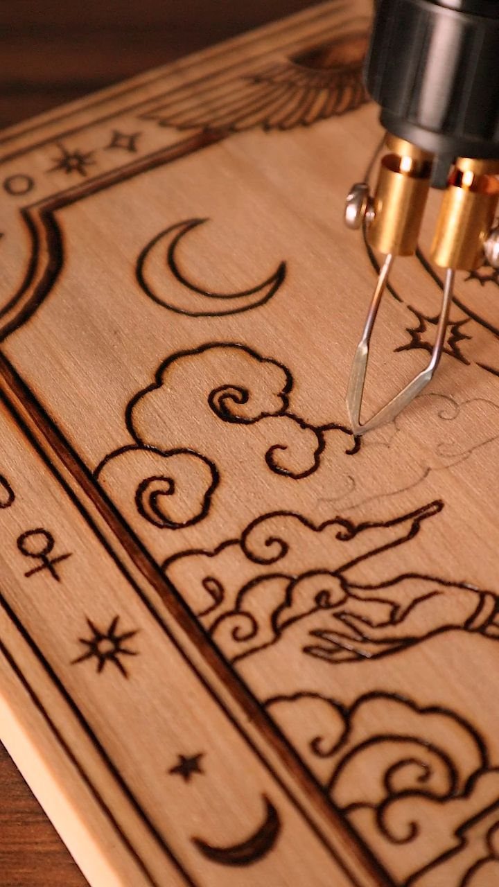 Wood Burning Carving Ideas: 7 Designs for Pyrography 7 Wood-burning tool etching a celestial design with a moon and clouds into wood