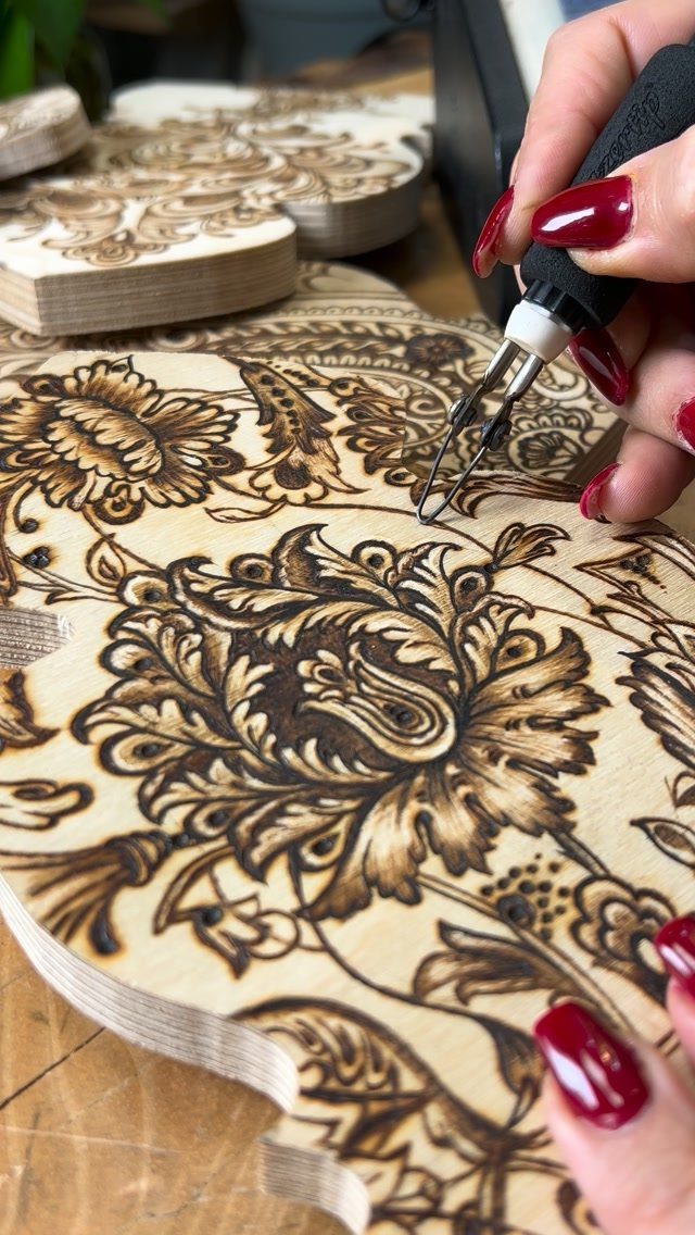 Wood Burning Carving Ideas: 7 Designs for Pyrography 2 Wood burning tool creating an intricate floral pattern on a light wooden board.