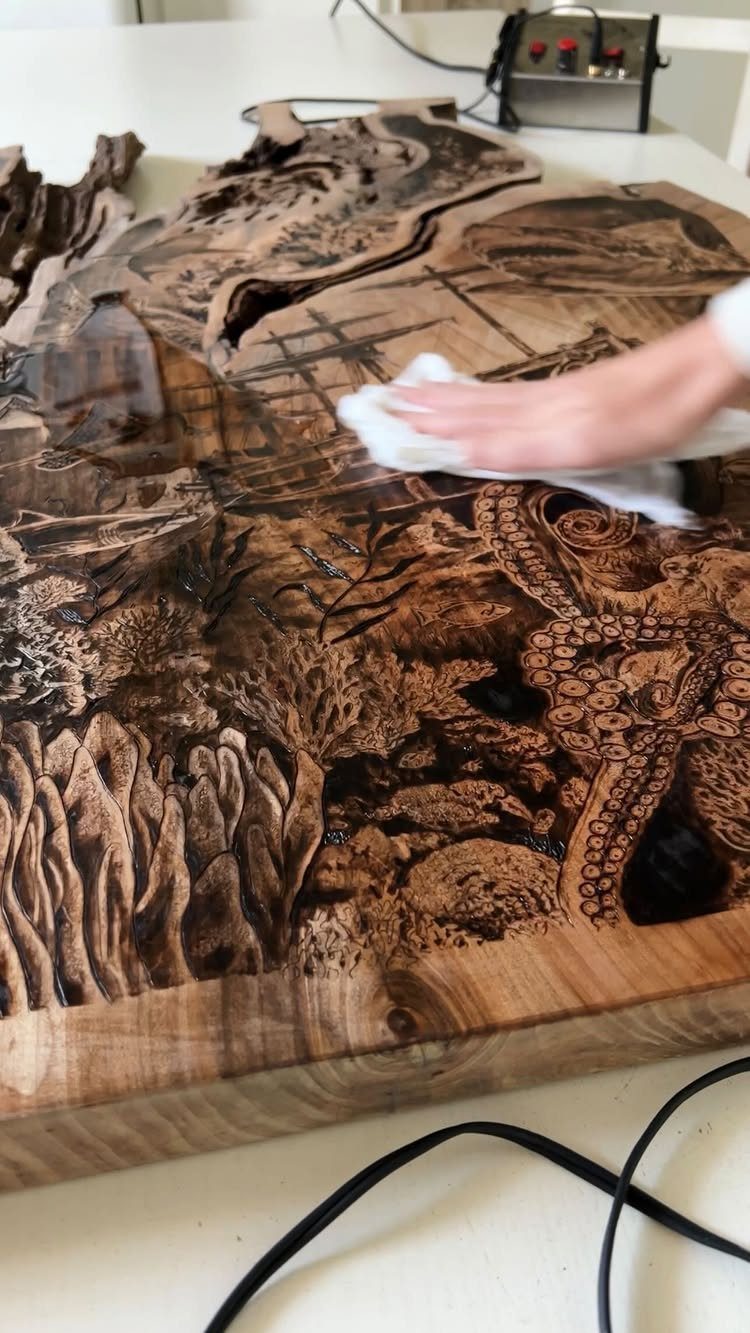 Wood Burning Carving Ideas: 7 Designs for Pyrography 5 Detailed wood burning carving on a natural slab being wiped with a cloth