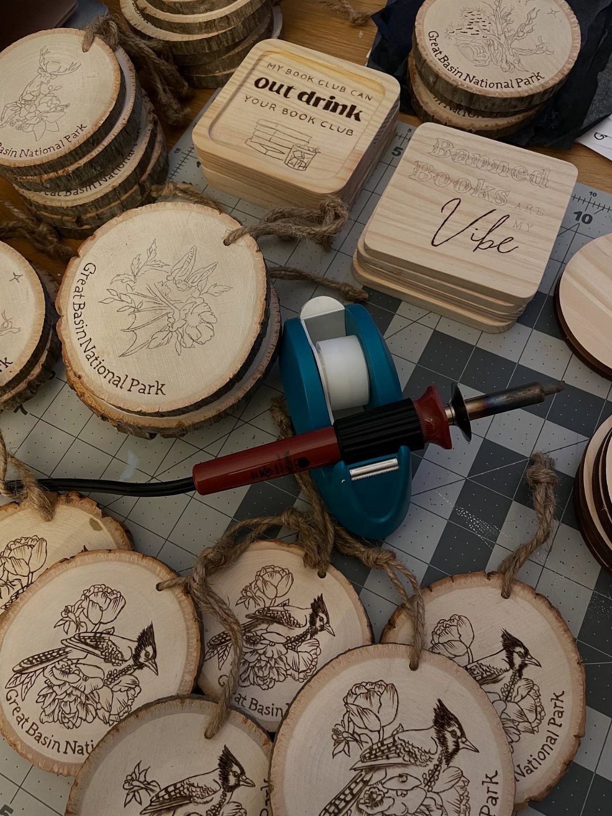 Wood burned circular ornaments with birds and flowers next to a burning tool.