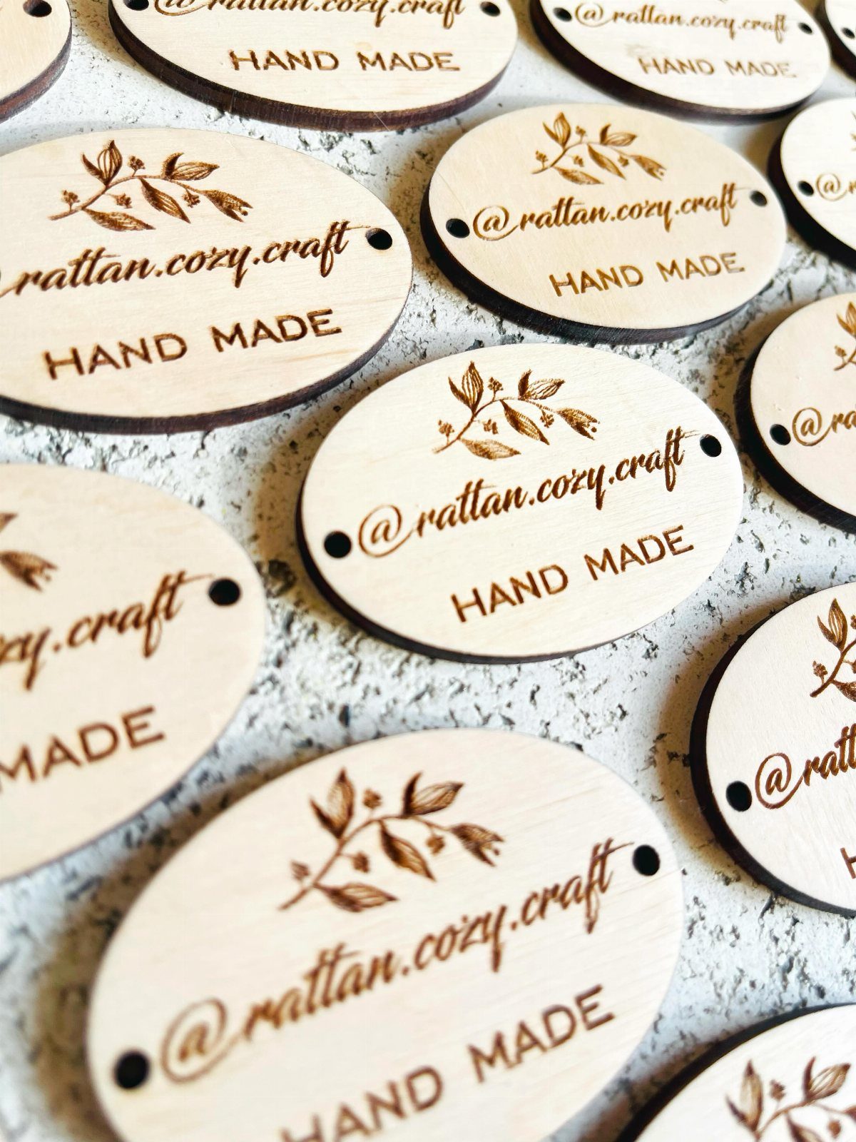 Oval wooden labels with burned text and leaf designs on a textured background