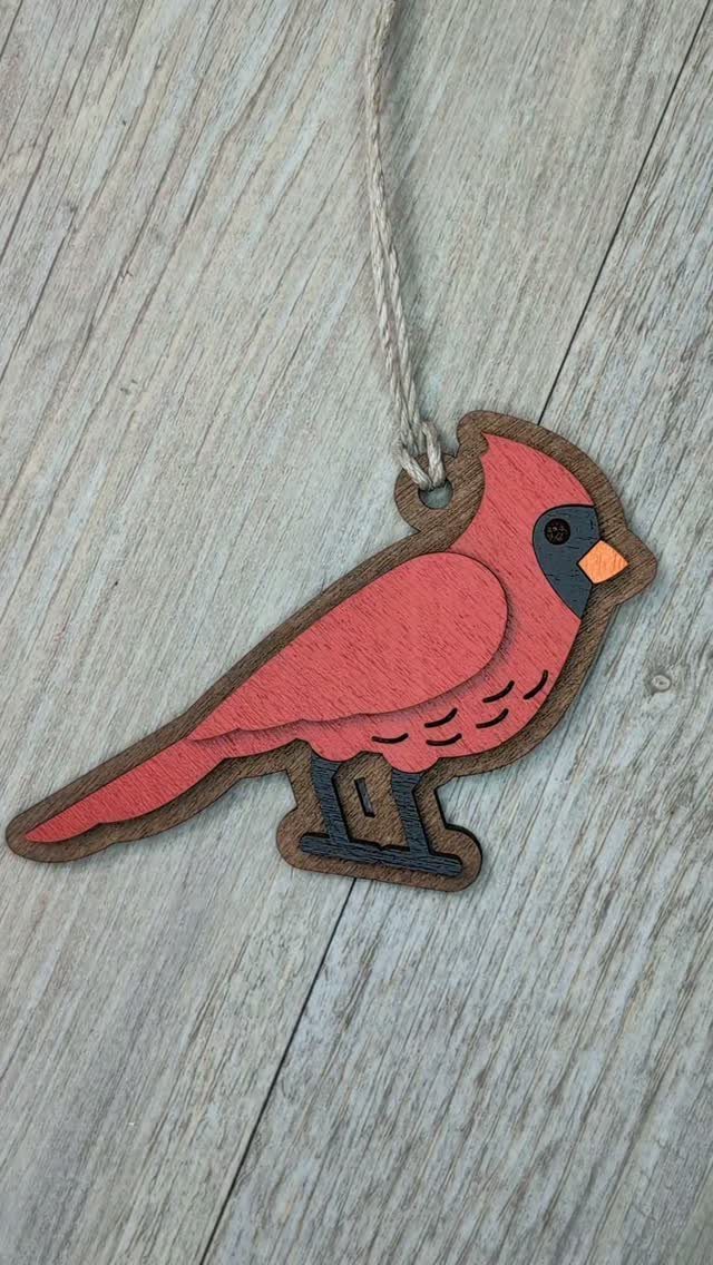 Wood Carved Ornaments: 7 Ideas for Holiday and Home 7 Red cardinal wood carved ornament hanging by twine on a grey wooden surface.