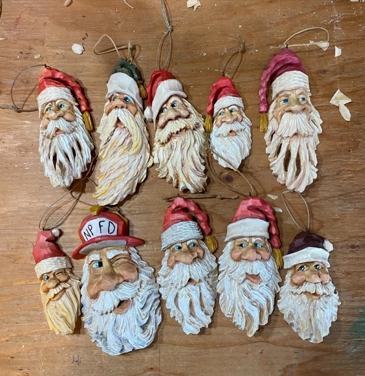 Wood Carved Ornaments: 7 Ideas for Holiday and Home 2 Hand-carved wooden Santa Claus head ornaments with white beards on a wooden background