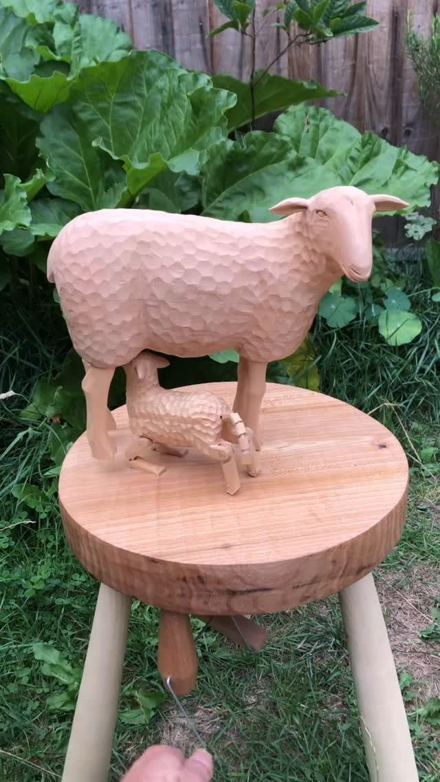 Wood Carving Animals: 14 Ideas to Try With a Knife 6 Wooden carving of a sheep and lamb on a round wooden stand outdoors.
