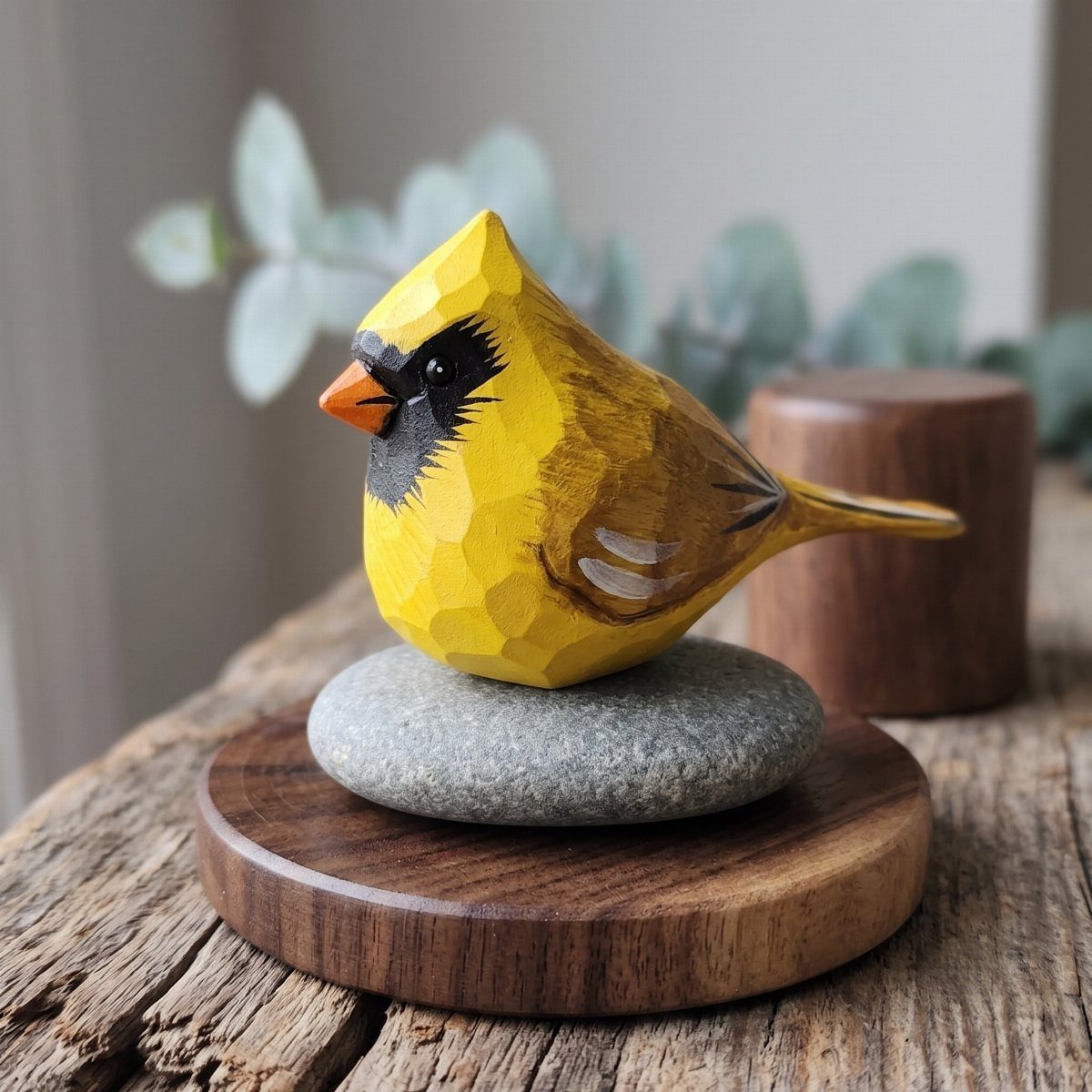 Wood Carving Animals: 14 Ideas to Try With a Knife 8 Yellow carved wooden bird with black face perched on a grey stone base