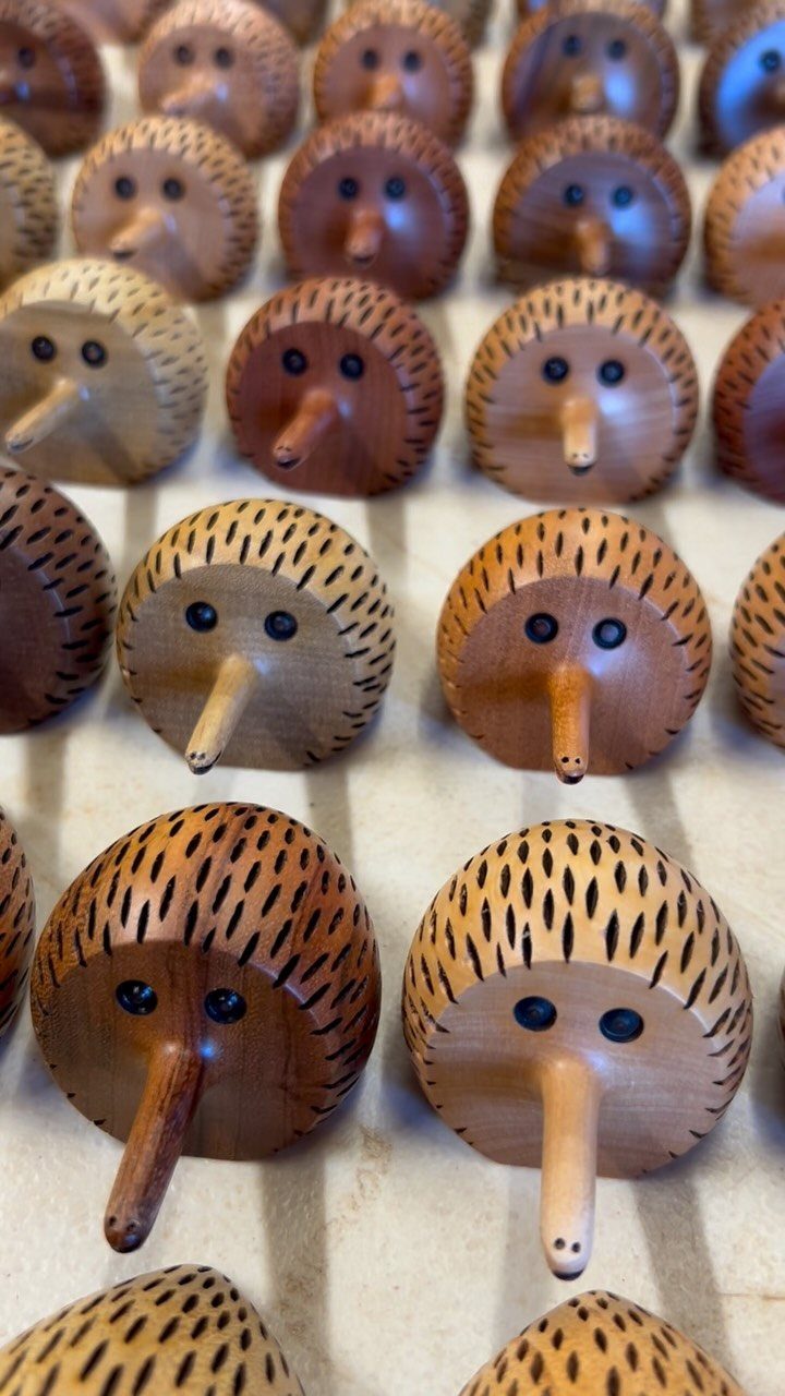 Wood Carving Animals: 14 Ideas to Try With a Knife 12 Carved wooden hedgehogs with round bodies and long noses arranged in rows.
