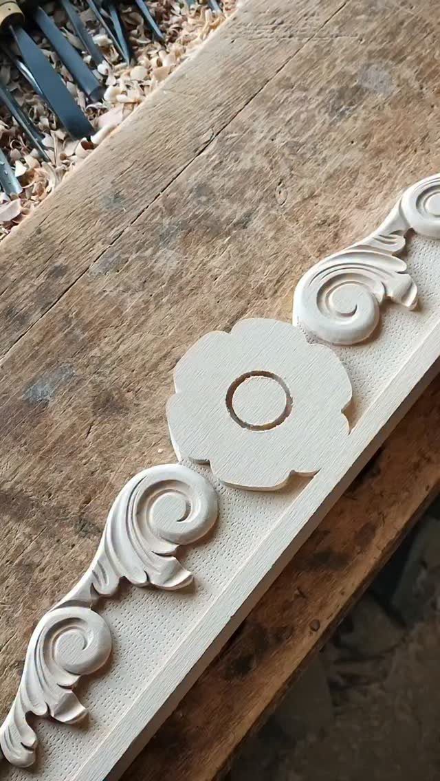 Wood Carving for Beginners: 10 Ideas to Try First 1 Floral and scrollwork relief carving on a light-colored wooden plank on a workbench.