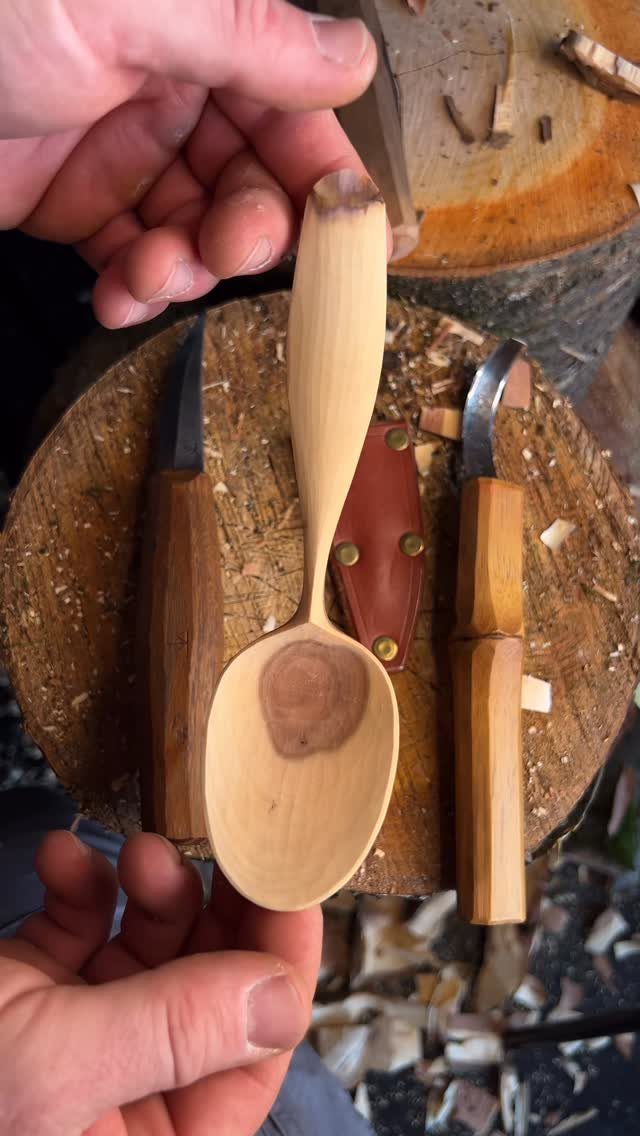 Wood Carving for Beginners: 10 Ideas to Try First 2 Hand-carved wooden spoon held over a log workbench with carving knives and shavings.