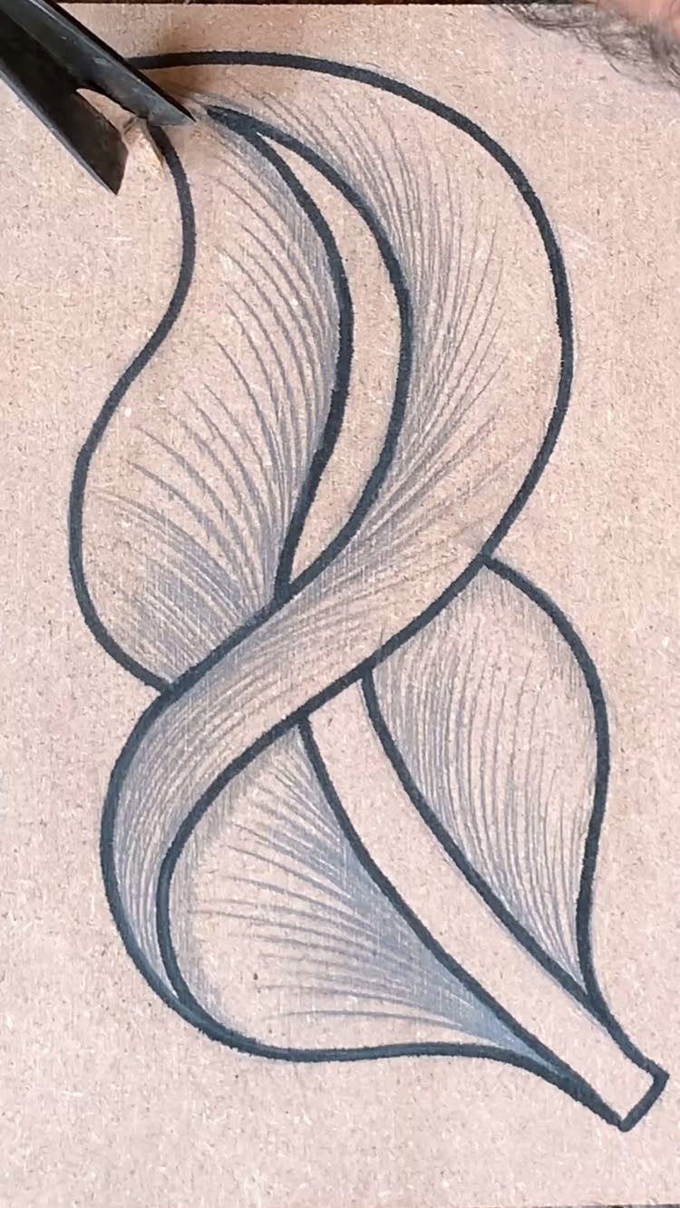 Abstract flowing ink pattern drawn on wood with a carving tool nearby