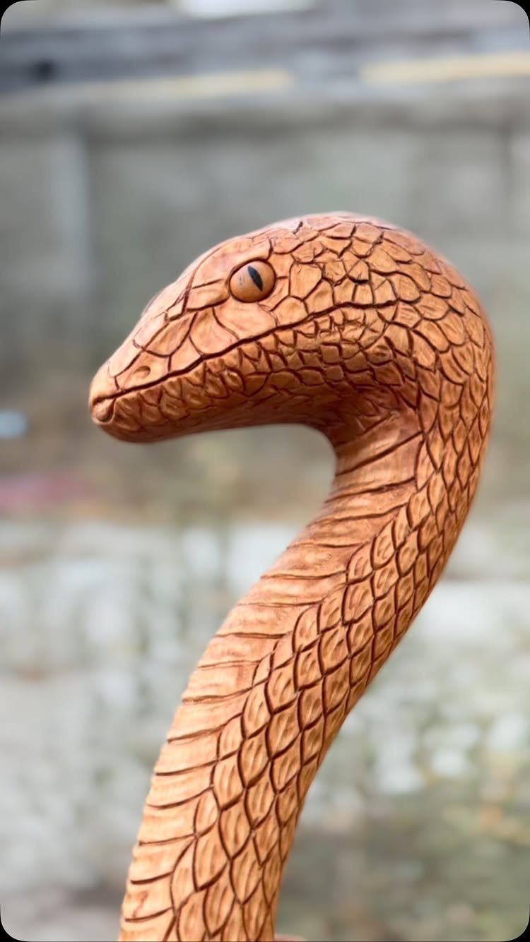 6 Wood Carving Snake Ideas for Every Skill Level 5 Wood carving of a snake with detailed scales and a curved neck.