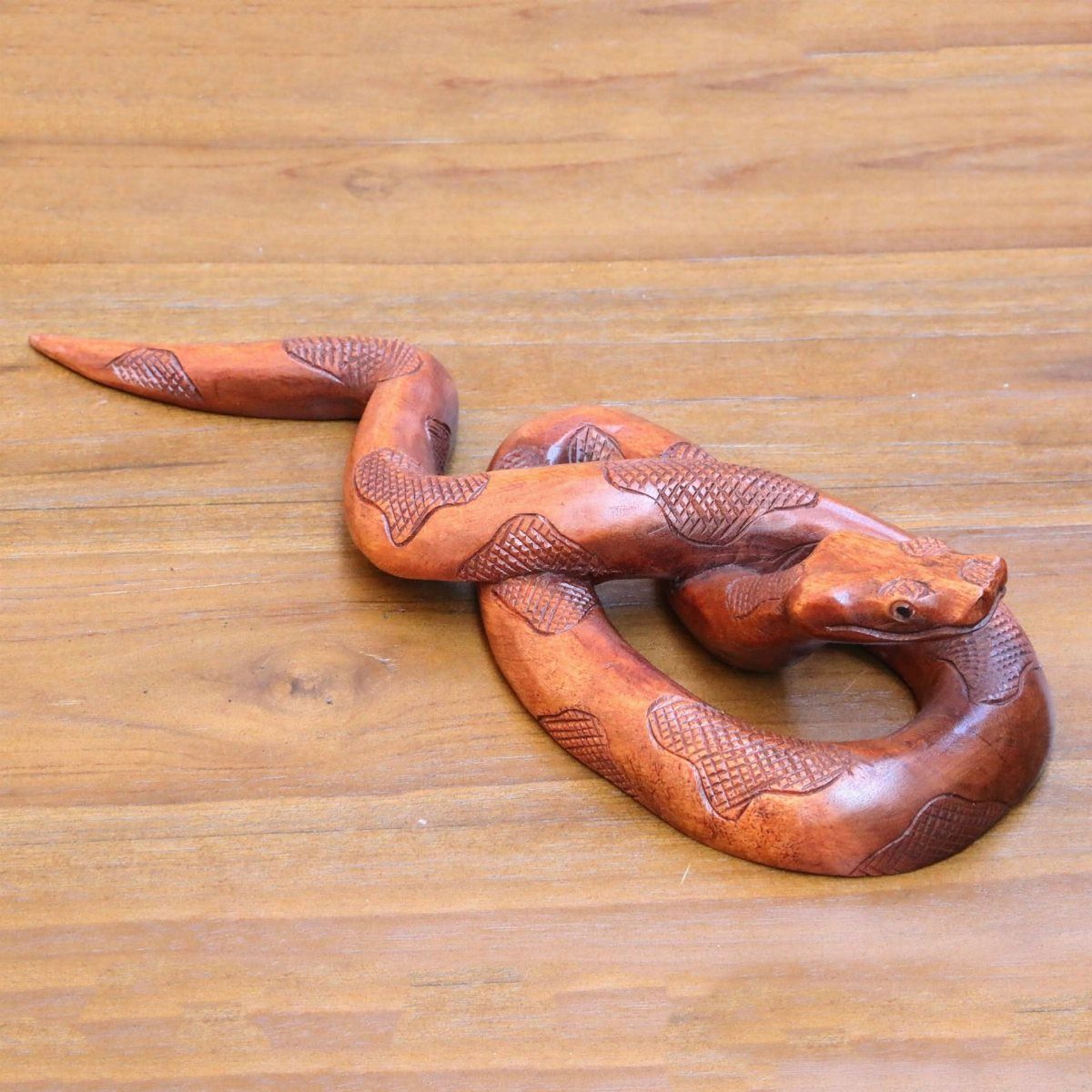 6 Wood Carving Snake Ideas for Every Skill Level 1 Wooden snake sculpture with detailed scales coiled on a light wood surface.
