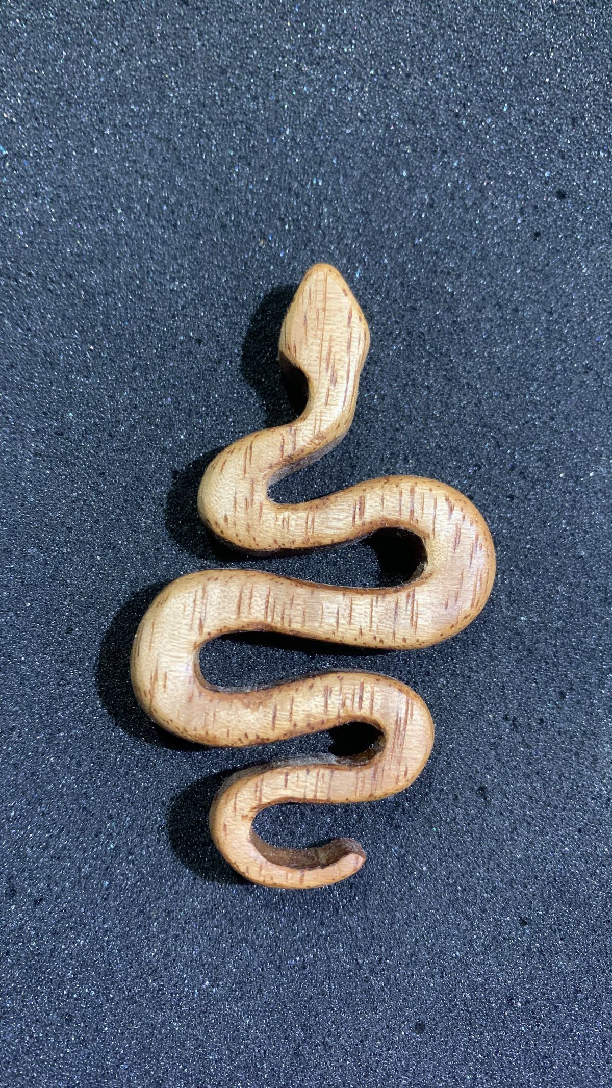 6 Wood Carving Snake Ideas for Every Skill Level 4 Wooden snake carving with a curved body on a dark grey background