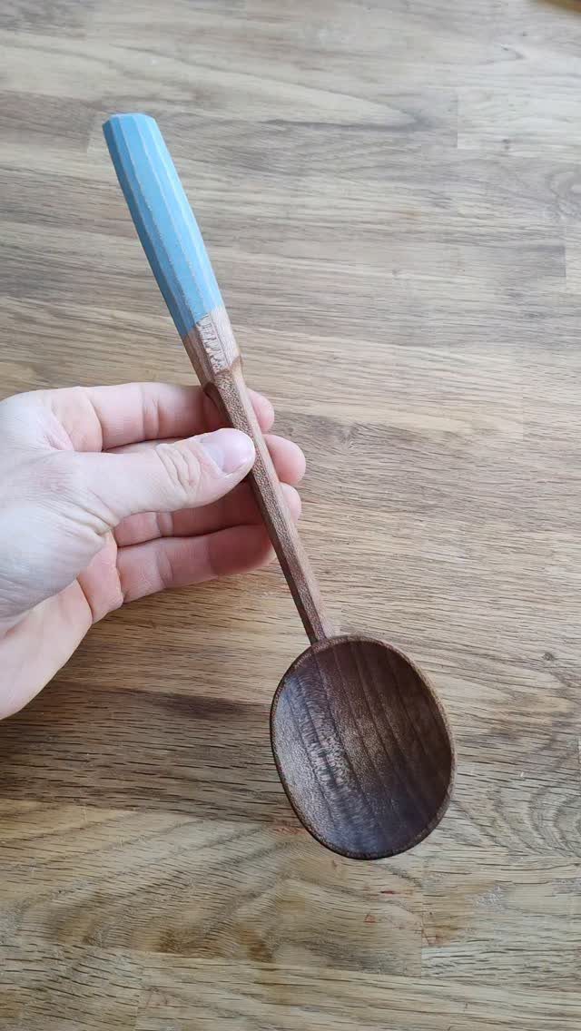 5 Wood Carving Tutorials for Spoons, Waves and Fairy Houses 1 Hand-carved wooden spoon with a blue painted handle held over a wooden table.