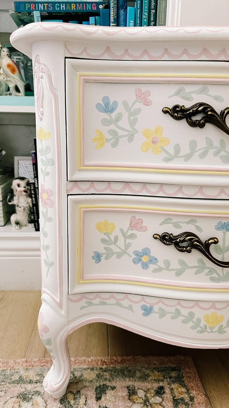 White wooden dresser decorated with hand-painted colorful floral folk art designs.