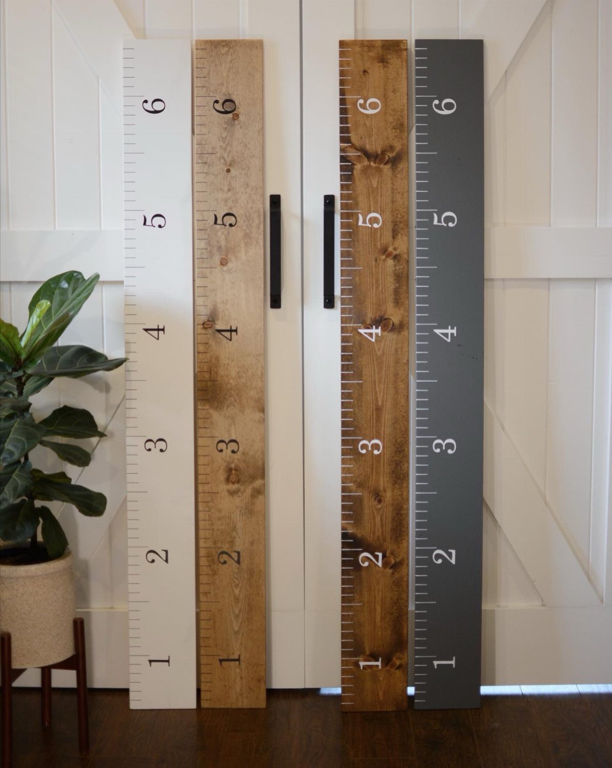 14 Wood Ideas to Sell: Easy Projects for Craft Fairs 12 Four wooden growth charts in different colors leaning against white barn doors.