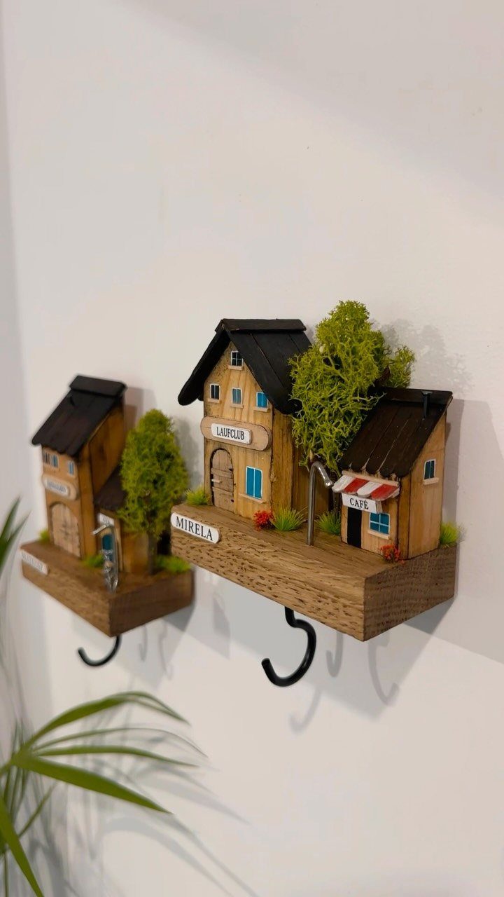 14 Wood Ideas to Sell: Easy Projects for Craft Fairs 6 Miniature wooden house dioramas mounted on blocks with black key hooks on a wall