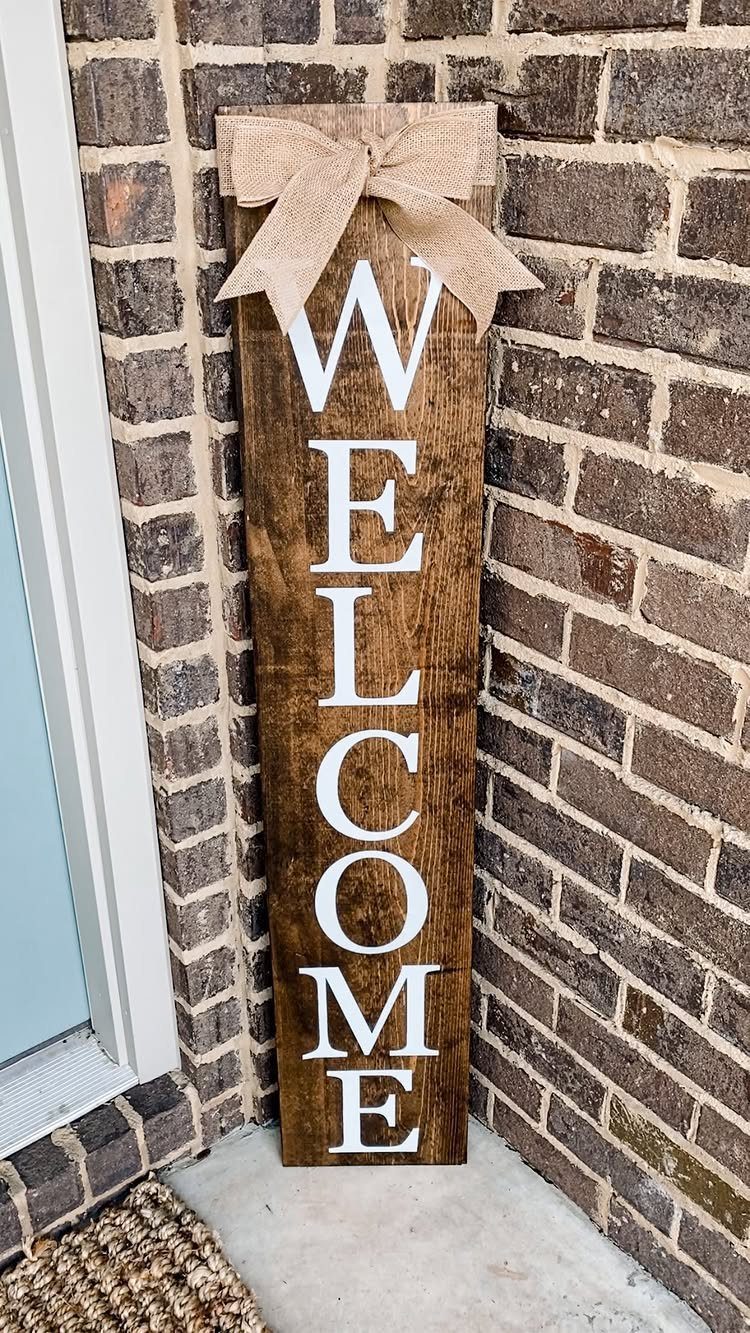 14 Wood Ideas to Sell: Easy Projects for Craft Fairs 1 Wooden welcome sign with a burlap bow leaning against a brown brick wall.