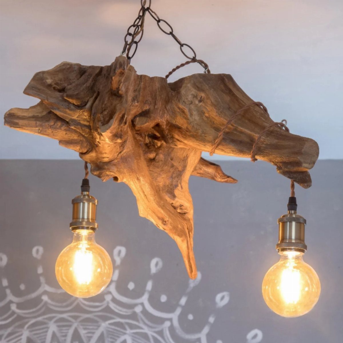 Wood Lamp Design: 14 Table, Floor and Pendant Ideas 11 Driftwood hanging lamp with two glowing Edison bulbs suspended by a metal chain.